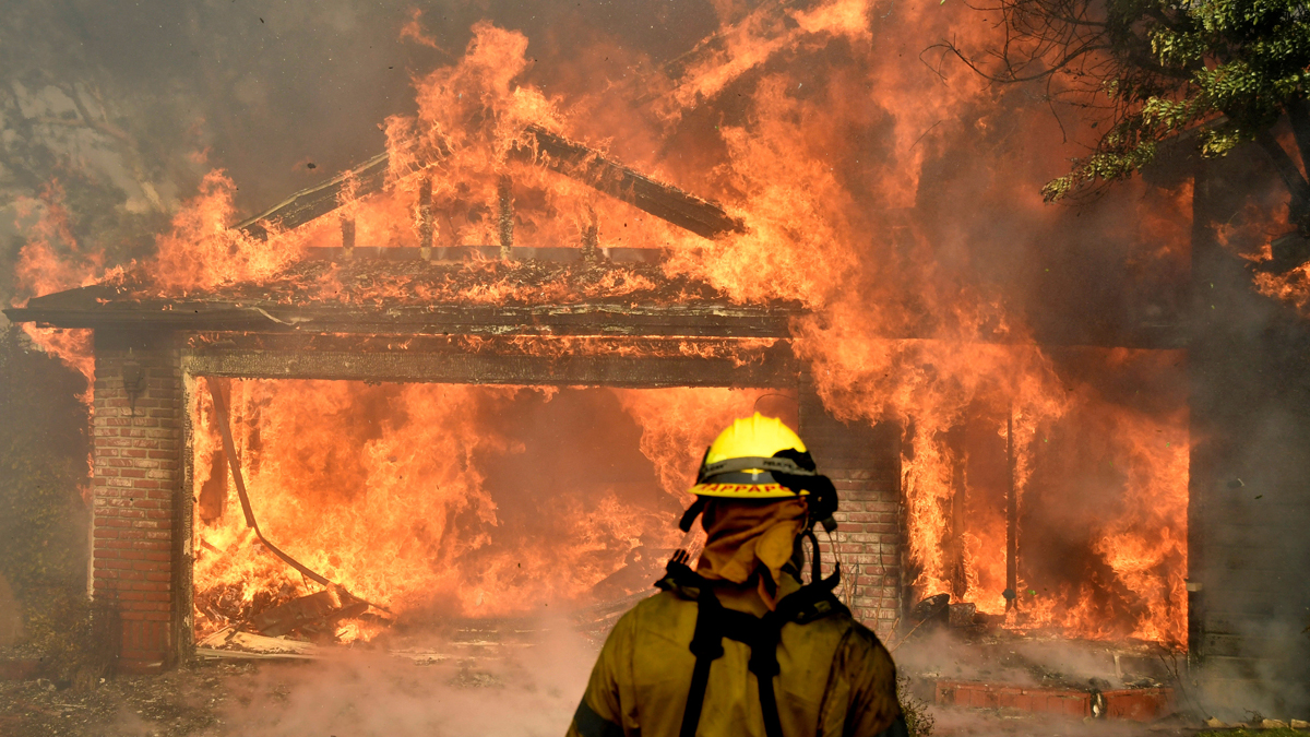 Bombero observa casa en llamas intensas