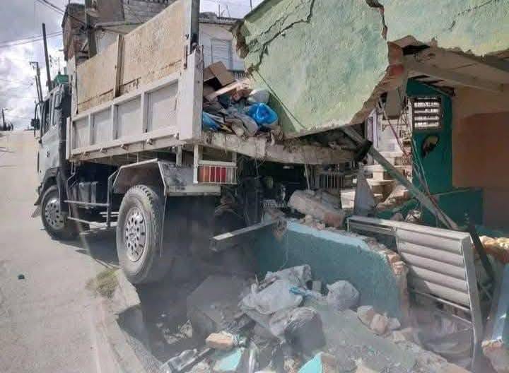 Camión embistiendo casa en la calle
