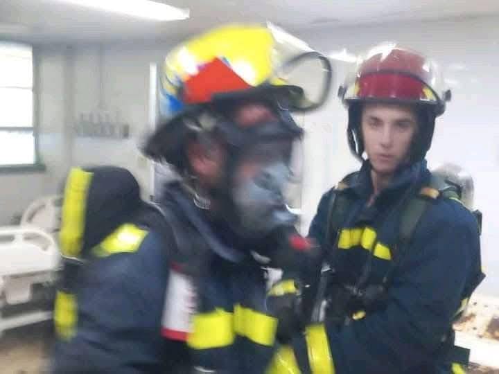 Bomberos con equipo completo en entrenamiento