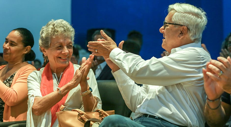 Dos adultos mayores felices aplaudiendo en evento