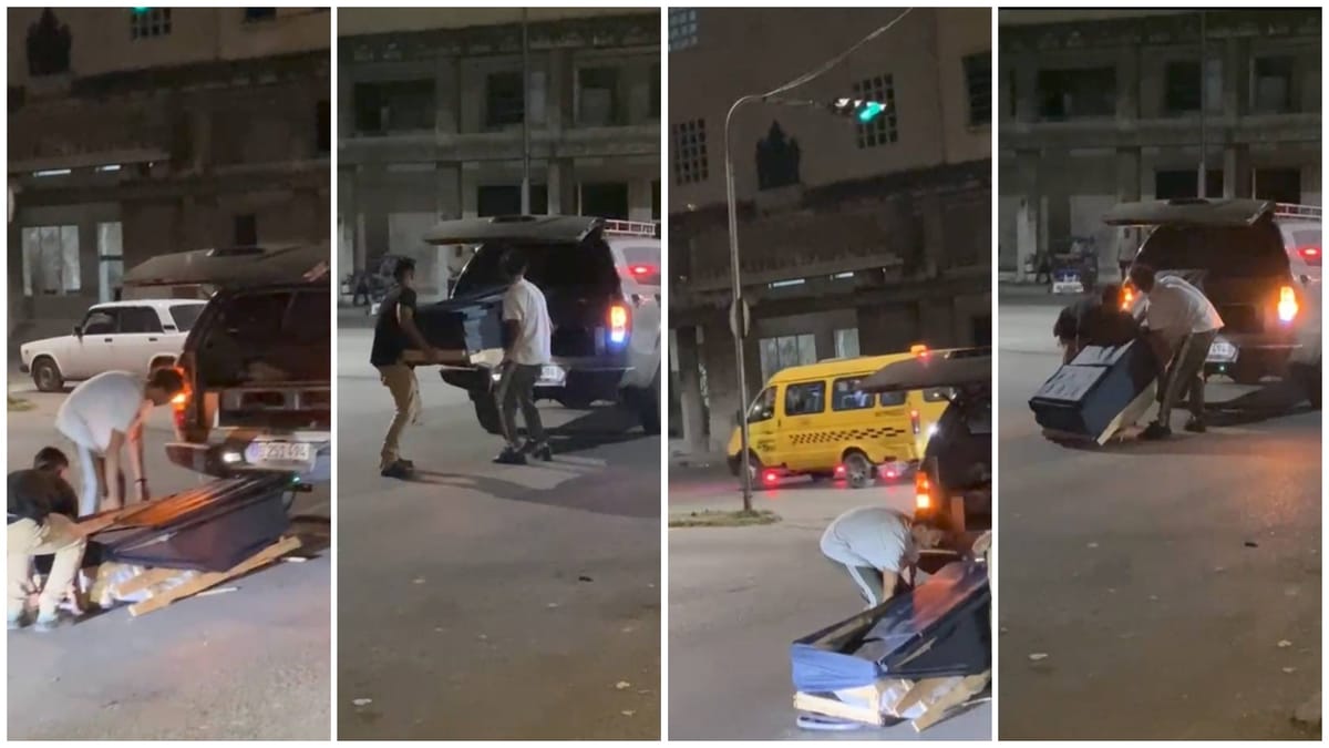 Personas cargando mueble en vehículo por la noche