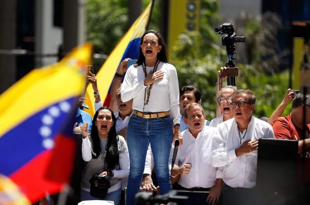 Mujer liderando protesta con banderas de Venezuela
