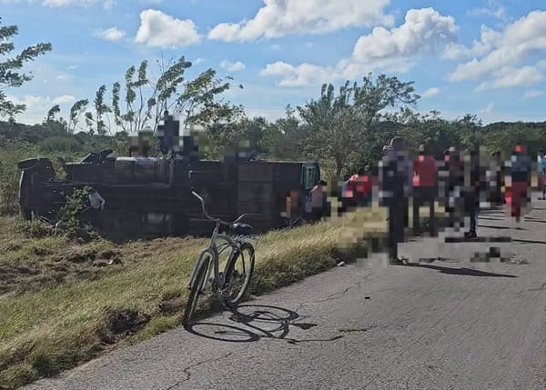 Camión volcado en carretera con personas y bicicleta