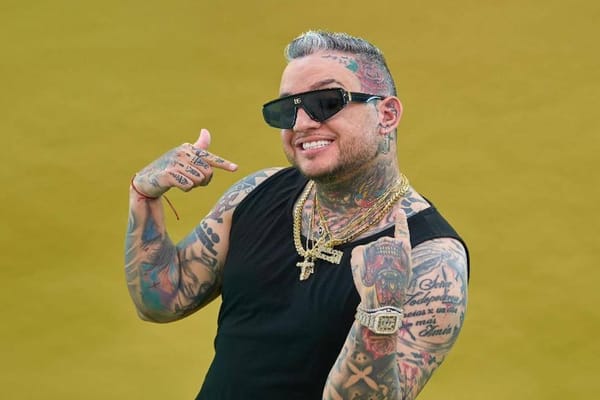 Hombre sonriente con tatuajes y gafas de sol