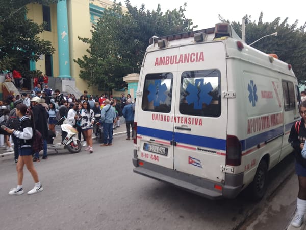 Ambulancia y multitud en calle urbana