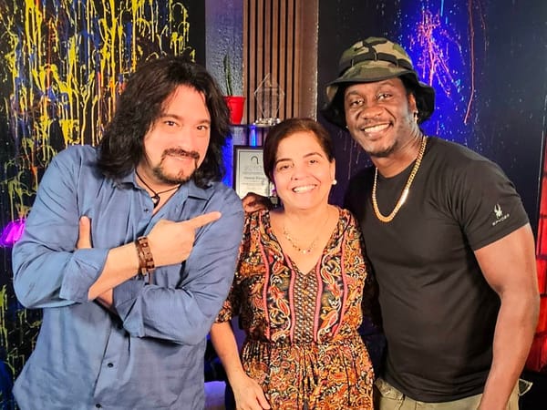 Tres personas sonriendo en un estudio colorido