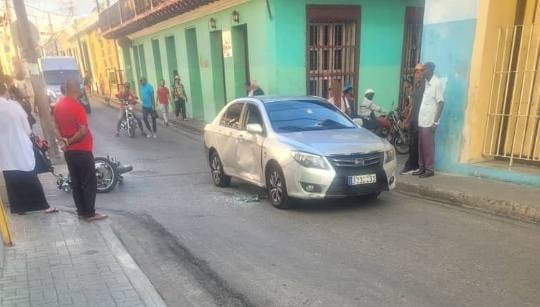 Coche plateado averiado en calle concurrida