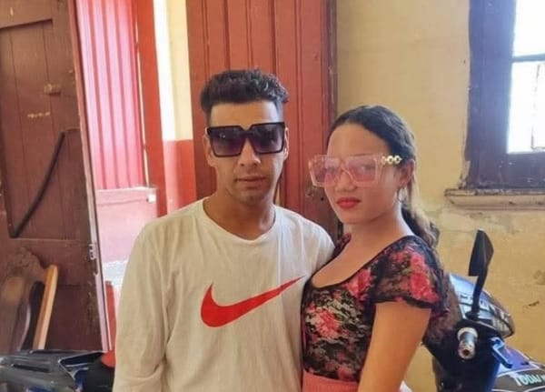 Hombre y mujer jóvenes posan con gafas de sol