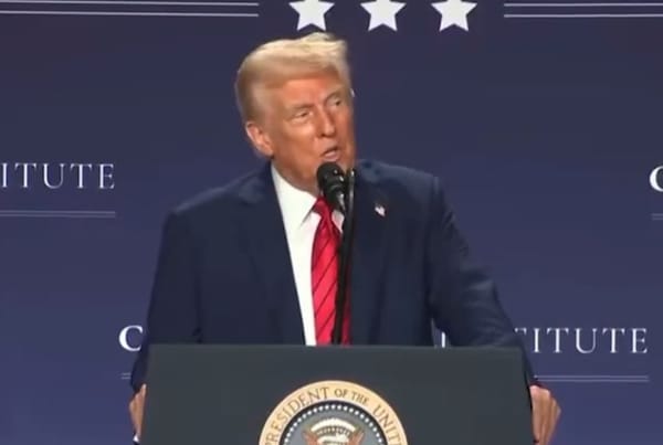 Hombre hablando en podio con insignias presidenciales