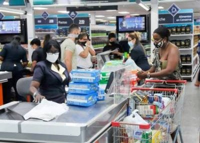 Personas comprando en supermercado con mascarillas