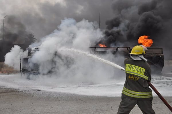 Bombero apagando incendio urbano con manguera