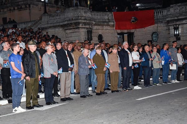 Grupo de personas con banderas en evento nocturno