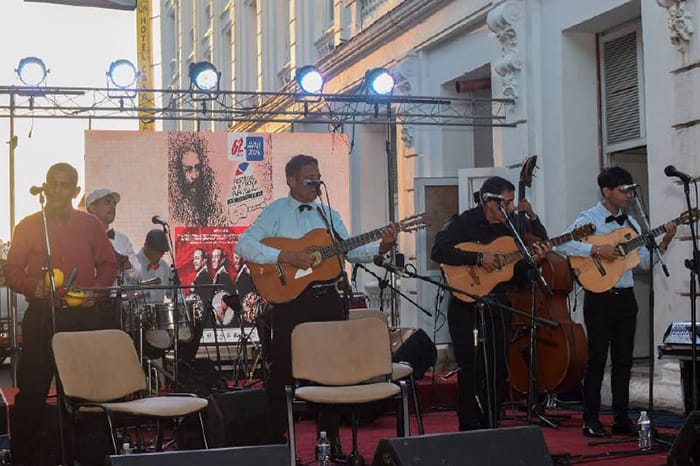 Grupo musical tocando en un escenario al aire libre.