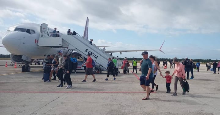 Pasajeros desembarcando de un avión en aeropuerto.