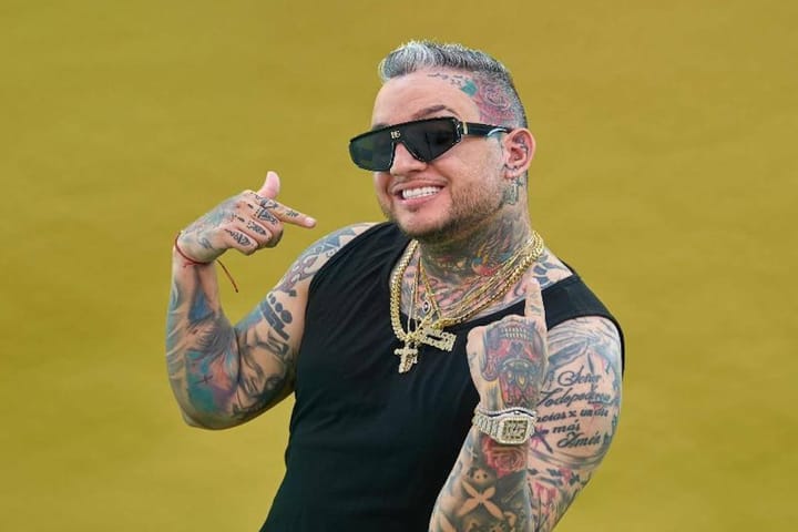 Hombre sonriente con tatuajes y gafas de sol