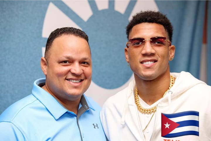 Dos hombres sonrientes con camisas y colgantes