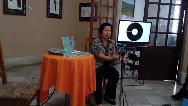 Mujer dando conferencia con micrófono y proyector