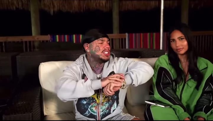 Hombre y mujer jovenes en sofá durante entrevista nocturna