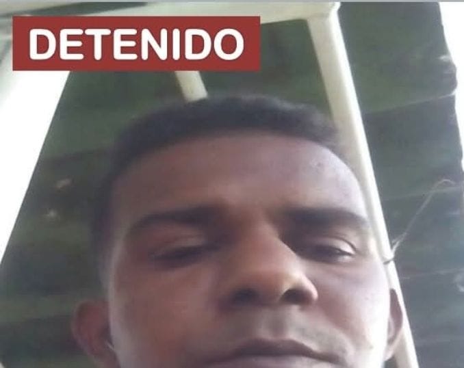 Hombre bajo cartel 'Detenido'