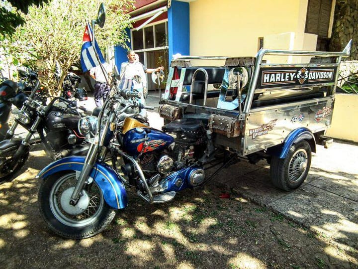Motocicleta Harley-Davidson con sidecar y bandera cubana.
