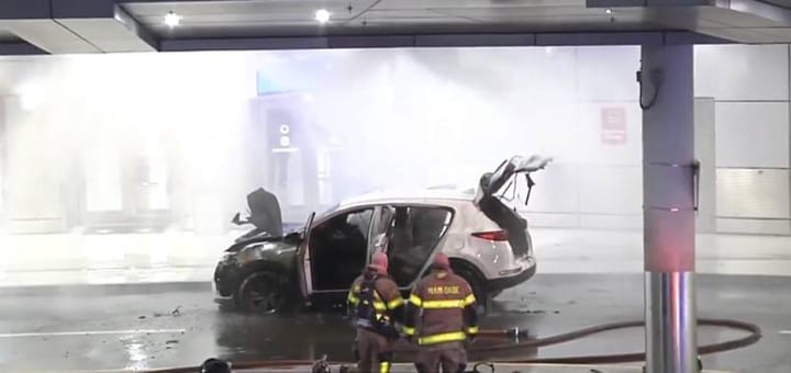 Bomberos apagan incendio en coche dañado.