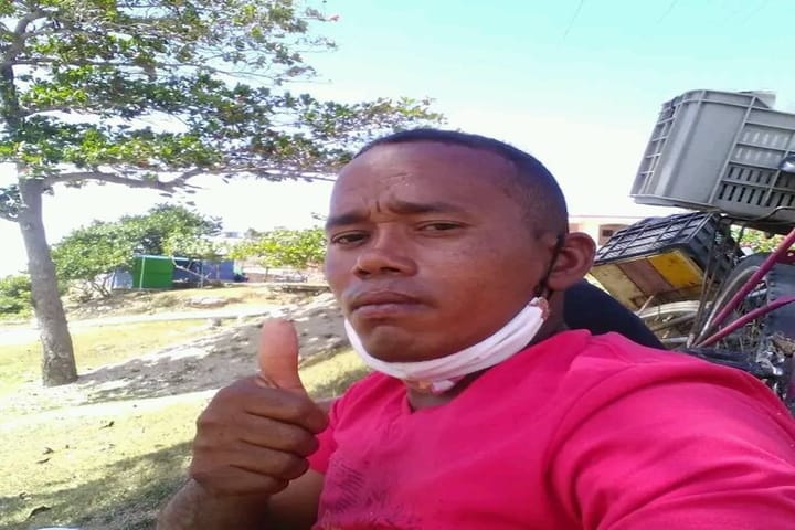 Hombre con pulgar arriba y mascarilla al aire libre.