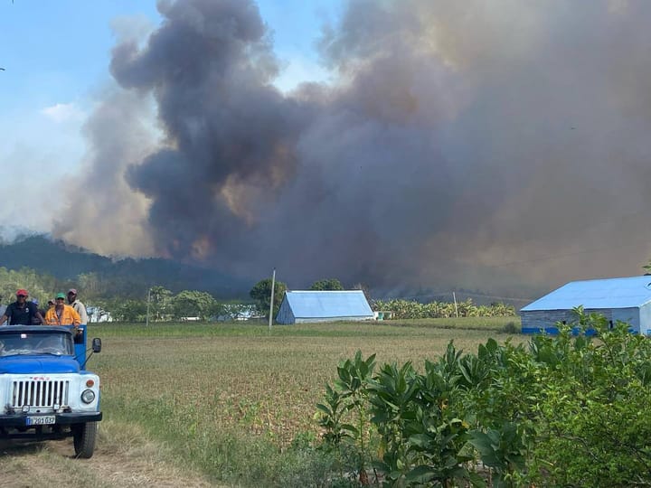Incendio forestal con humo y personal de emergencia