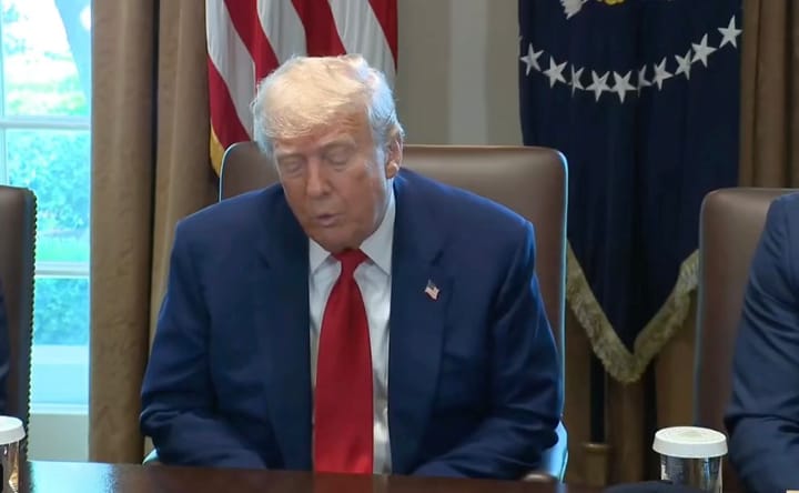 Hombre de traje azul en reunión oficial.