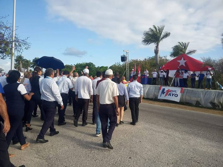 Evento al aire libre con personas y banderas.