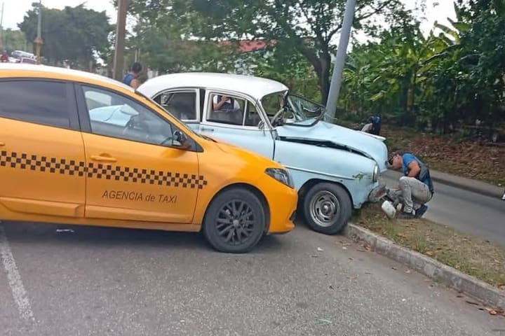 Colisión entre taxi y coche antiguo en carretera.