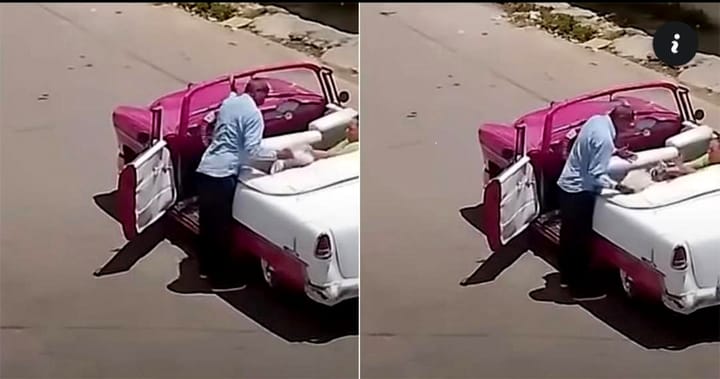 Hombre ayuda a mujer a salir del coche clásico.