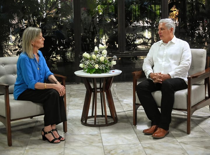 Reunión formal entre dos personas sentadas, interior elegante.