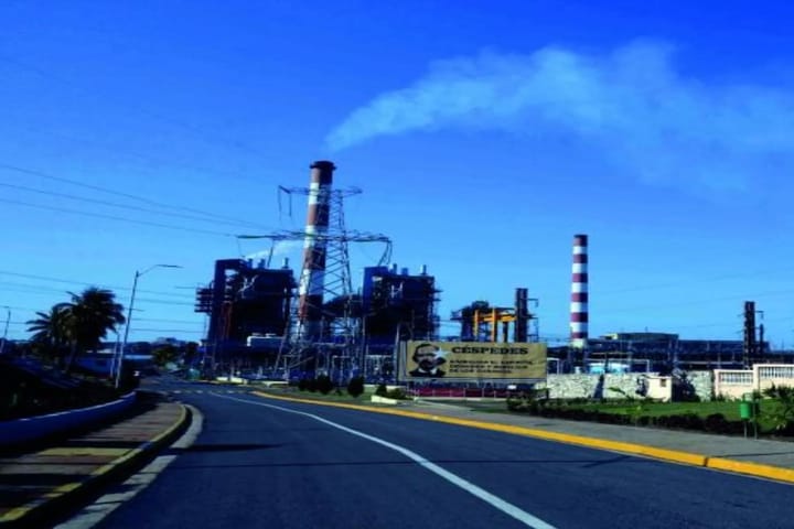 Central eléctrica con chimeneas y cartel visible