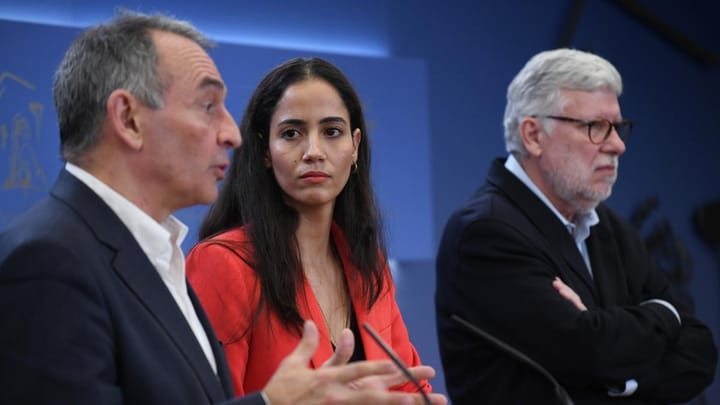 Tres personas discutiendo seriamente en una sala