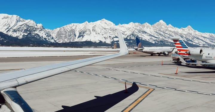 Aviones en pista con montañas nevadas al fondo