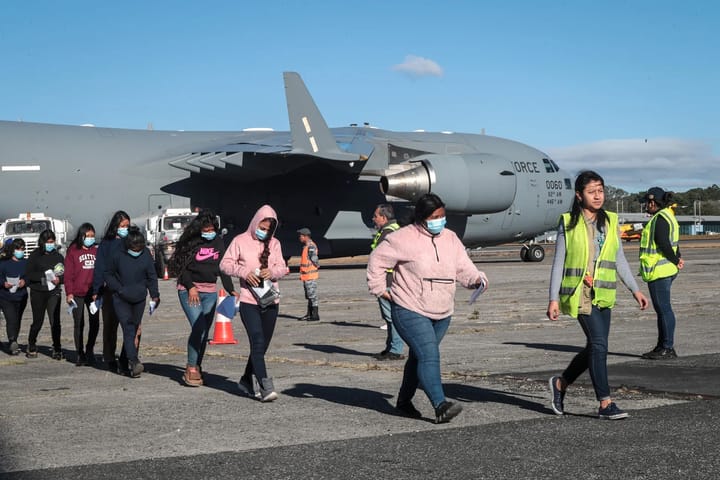 Personas caminando cerca de avión militar