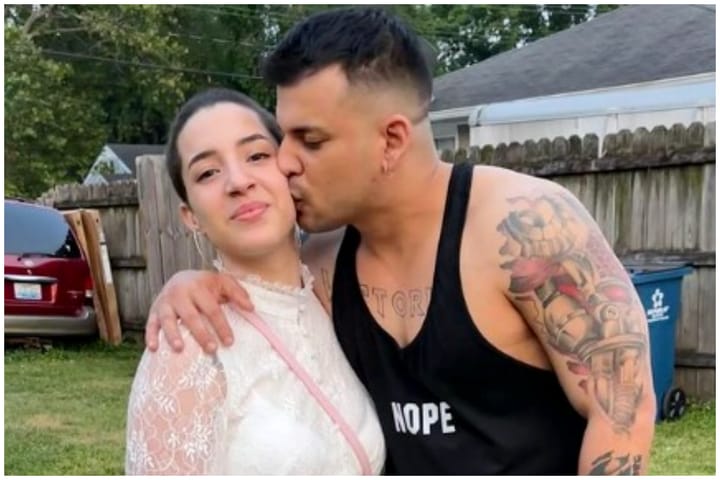 Hombre besando mejilla de mujer en jardín