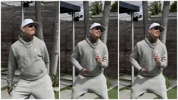 Hombre sonriente con gorra y cadena posando