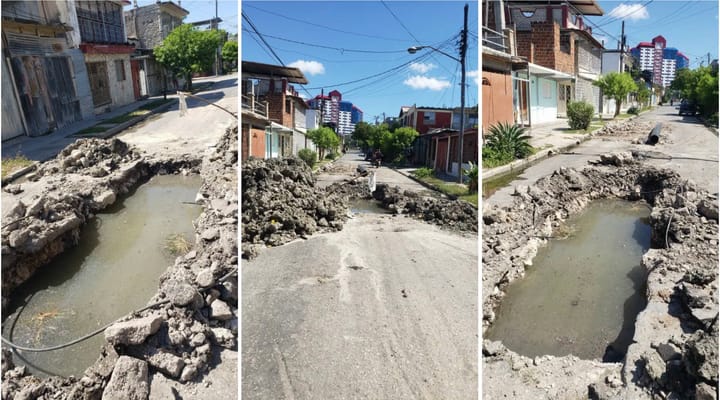 Calle dañada con baches y charcos de agua.