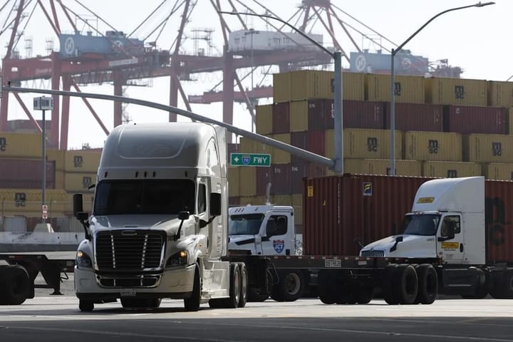 Camiones en puerto con contenedores.