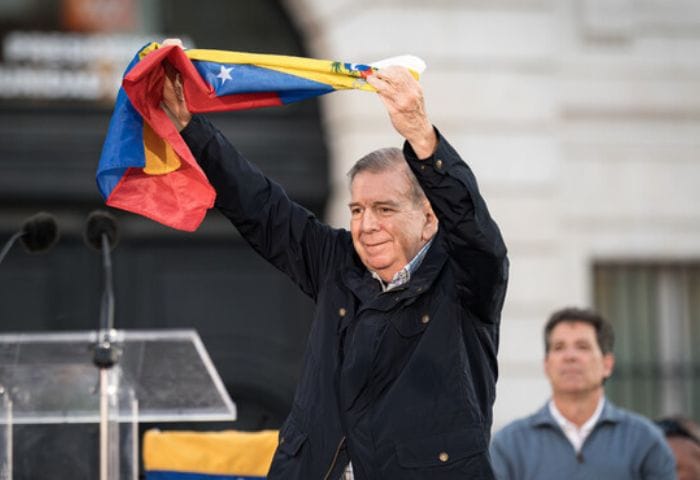 Hombre elevando bandera de Venezuela