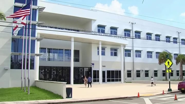 Fachada de una escuela secundaria moderna con banderas.