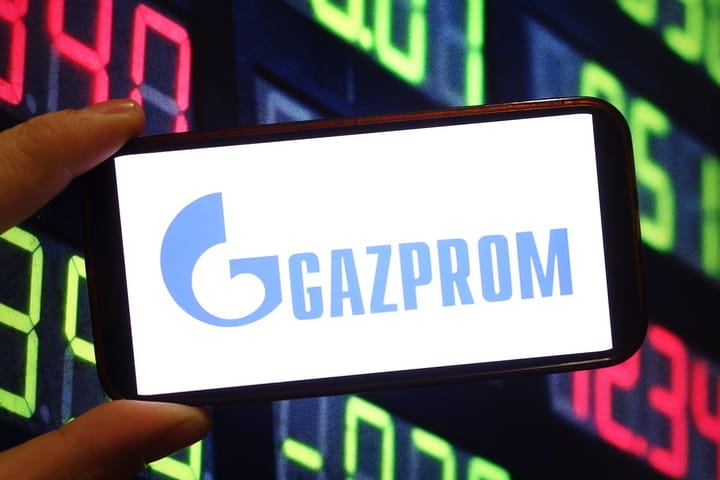 Móvil mostrando logo de Gazprom con gráficos de fondo
