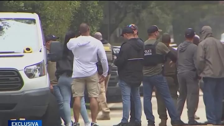 Reunión de policías junto a una furgoneta blanca.