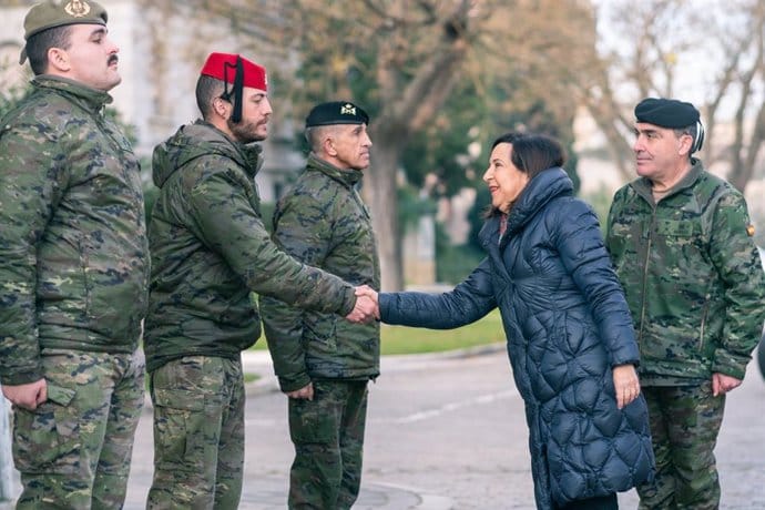 Mujer saludando a militares en fila