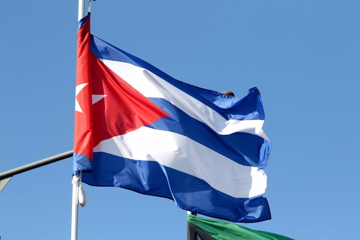 Bandera de Cuba ondeando bajo cielo azul
