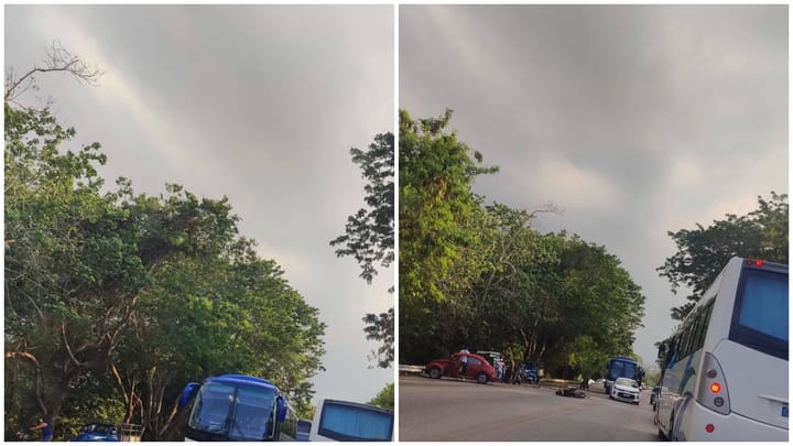 Autobuses en carretera con cielo nublado.