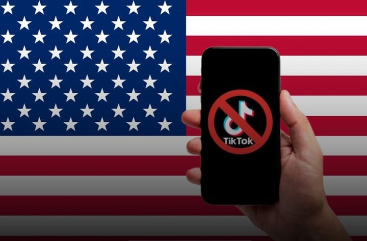 Móvil mostrando logo de TikTok prohibido sobre bandera de EE.UU.