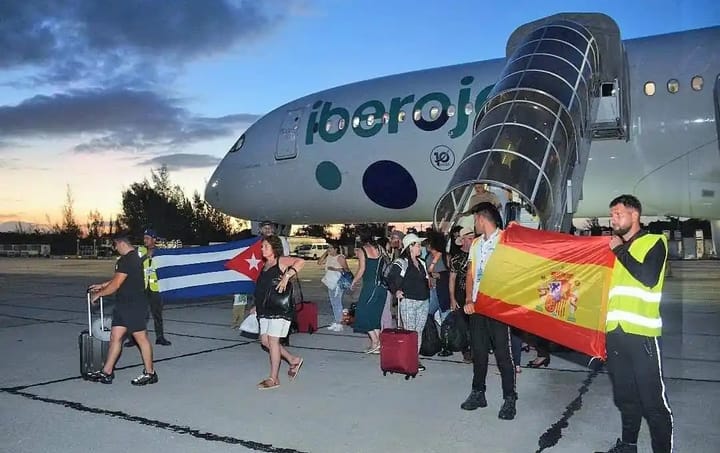 Pasajeros desembarcando de avión Iberojet con banderas