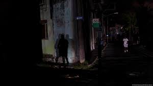 Calle oscura con sombras en la pared.